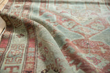 Distressed pile texture and softened raspberry red, sea foam green motifs on a vintage Malayer rug.