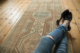 Distressed vintage Serab runner, showing wear and geometric medallions in beige, brown, powder blue.