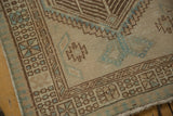 Distressed vintage Serab runner detail, geometric brown borders, powder blue motifs on beige, foundation showing.