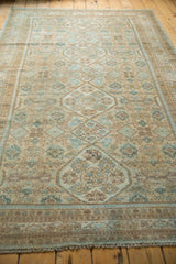 Distressed vintage Hamadan rug, close-up of textured pile with muted beige and blue motifs.
