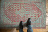Distressed vintage Mir Serbend rug showing its faded red and blue central medallion and boteh field.