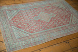 Distressed pale blue geometric border, faded cherry red field, and secured edge.