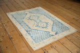 Distressed geometric indigo patterns along the khaki border of a Sivas rug.