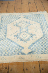 Distressed geometric patterns and short fringe on vintage Sivas rug in beige and indigo.