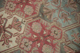 Distressed vintage Baktiari rug detail: multi-panel geometric lattice with curvilinear plum, teal, and ivory.