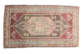 Vintage distressed Malayer rug with a geometric lozenge medallion, fuchsia and charcoal tones.