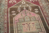 Distressed geometric medallion in blush, rose, and antique ivory on a vintage Malayer rug.