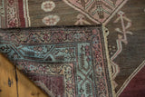 Distressed Malayer rug corner revealing hand-knotted construction and vibrant geometric borders.
