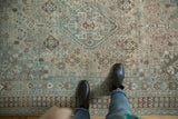 Distressed vintage Shiraz carpet's pale teal and brown traditional geometric patterns.