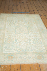 Distressed ivory field, sky blue floral geometric border, and fringe of a vintage Sivas rug.