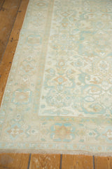 Fringe and faded floral geometric border on distressed vintage Sivas rug corner.