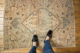 Distressed Hamadan rug texture revealing low pile and geometric motifs in sand beige, sky blue.