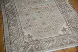 Distressed Hamadan pile with visible foundation wear, serrated border, and faded heart motifs.
