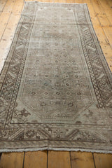 Distressed Hamadan runner corner with serrated leaf border, worn pile, and fringe.