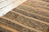 Banded plain weave and geometric patterns on a vintage Jijim rug in dark brown and coffee.