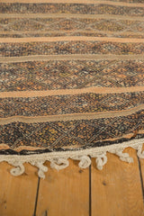 Braided fringe and densely woven patterned bands in chocolate, orange, and pale brown.