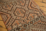 Intricate hand-woven geometric detailing of the Jijim runner, in brown, ivory, and tangerine.