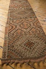 Intact braided fringe and intricate banded geometric patterns in warm earth tones.