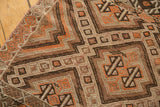 Intricate hand-woven geometric patterns in brown, ivory, and tangerine on the vintage Jijim runner.