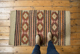 Hand-woven vintage Jijim rug with banded geometric diamond motifs in ivory, orange, and red.