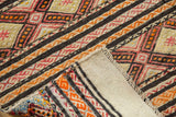 Vintage Jijim rug corner detail, revealing plain ivory back and geometric banded design.