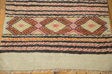 Vintage Jijim rug's plain weave base, fringe, and bold tangerine, raspberry patterned bands.
