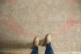Distressed vintage Oushak rug, showing its pale blush, silver, and ivory tones, and foundation wear.