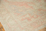 Worn pile texture of a distressed Oushak rug, showing faint blush and ivory hues.