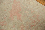 Textured detail of distressed vintage Oushak carpet, showing even wear and dusty blush motifs.