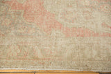 Distressed vintage Oushak carpet surface with even wear, faint foundation, and pale blush.