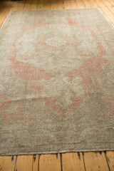 Textural detail of the distressed Oushak rug's dusty blush pattern and worn foundation.