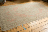 Distressed vintage Oushak carpet with a soft dusty blush field and faded medallion.