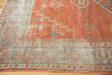 Textured brick red Mahal rug with worn areas revealing lighter tones and geometric border.
