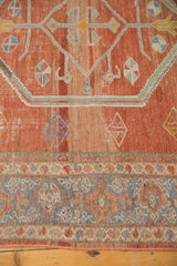 Distressed geometric brick red field and intricate blue border of a vintage Mahal rug.