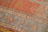 Distressed brick red field and patterned blue and beige borders of a vintage Mahal carpet.