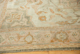 Vintage distressed Oushak carpet pile showing ivory, dark gold, and soft peach floral designs.