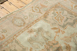 Distressed Oushak rug corner with playful ivory, oxidized silver, and gold floral motifs.