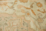 Textural close-up of worn distressed Oushak pile, ivory, soft pink, and antique gold.