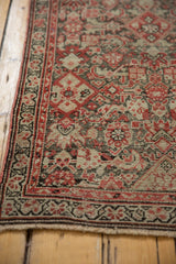 Antique Malayer runner corner showing brick red Herati motif, blush, and time-softened silver tones.