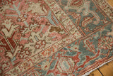 Distressed vintage Heriz rug close-up, geometric contours in blush, ivory, dusty blue.