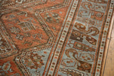 Geometric patterns of a distressed Afshar rug in chestnut rust and pale blue, with visible wear.