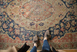 Distressed Sivas carpet detail: faded navy, blush, and ivory medallion with even wear.