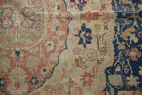 Distressed Sivas carpet with blush, navy, ivory floral patterns, showing mostly even wear to knot heads.