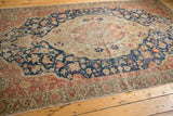 Distressed vintage Sivas rug corner, showing even wear, blush, navy, and ivory floral border.