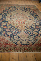 Distressed Sivas carpet border with blush, navy, ivory hues, and visible pile wear.
