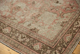 Vintage distressed Oushak carpet corner, with chocolate brown border and pale blush motifs.