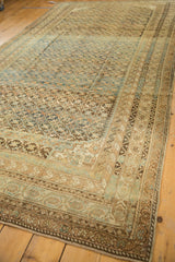 Intricate geometric border of an antique Caucasian carpet in brown, gold, and sky blue.