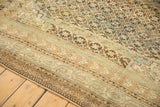 Antique Caucasian carpet with intricate geometric border and repeating starburst field in time-softened hues.