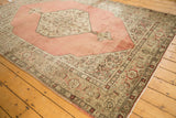 Distressed Tabriz carpet corner with low pile, dusty blush rose, Samovar border, and Herati spandrel.