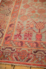 Distressed vintage Khotan rug texture, pale seafoam green field, tangerine pomegranate motifs.